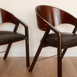 Jaume Tresserra Spinnaker armchairs — close-up of sculptural walnut frame and faux leather seat