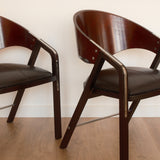 Jaume Tresserra Spinnaker armchairs — close-up of sculptural walnut frame and faux leather seat