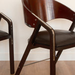 Jaume Tresserra Spinnaker armchairs — angled front view highlighting crescent-shaped backrest