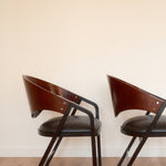 Jaume Tresserra Spinnaker armchairs — rear three-quarter view showing flowing walnut frame
