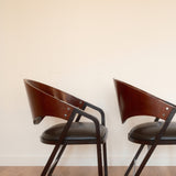 Jaume Tresserra Spinnaker armchairs — rear three-quarter view showing flowing walnut frame