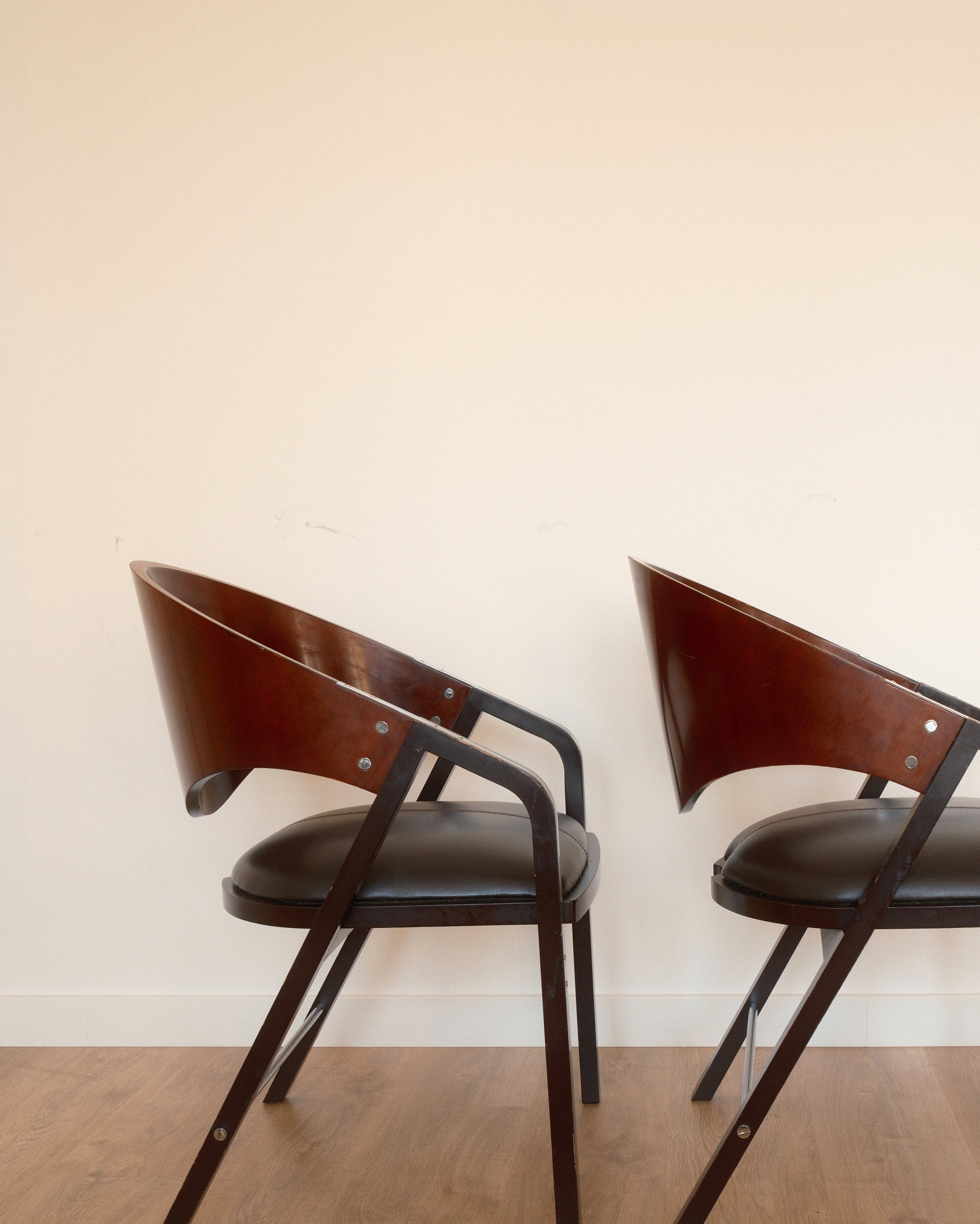 Jaume Tresserra Spinnaker armchairs — rear three-quarter view showing flowing walnut frame